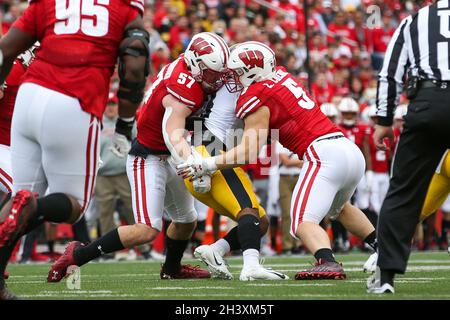 Madison, WI, USA. 30th Oct, 2021. Wisconsin Badgers linebacker Jack Sanborn (57) and linebacker Leo Chenal (5) tackle Iowa Hawkeyes running back Tyler Goodson (15) during the NCAA Football game between the Iowa Hawkeyes and the Wisconsin Badgers at Camp Randall Stadium in Madison, WI. Darren Lee/CSM/Alamy Live News Stock Photo