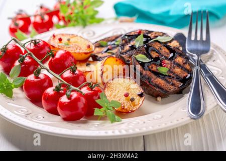 Delicious grilled eggplant steaks with vegetables. Stock Photo