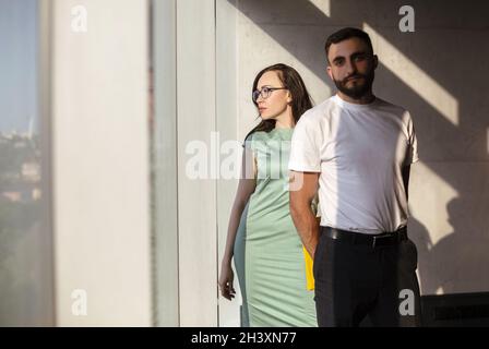 Two young focused coworkers, woman and man standing in office Stock Photo