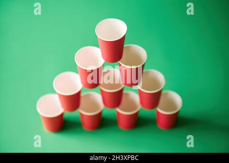 Pyramid of pink paper cups on green background. Stock Photo