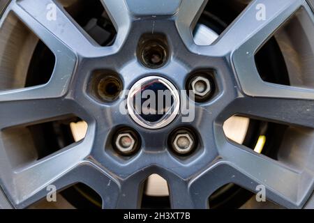 A close up view of the rim and wheel of a car with two broken lug nuts Stock Photo