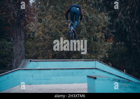 Professional young sportsman cyclist with bmx bike at skatepark. Stock Photo