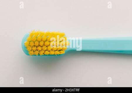 Yellow bristle toothbrush macro shot on white background. Stock Photo