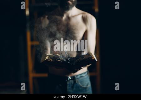 Man hold burning book in his hands. Stock Photo