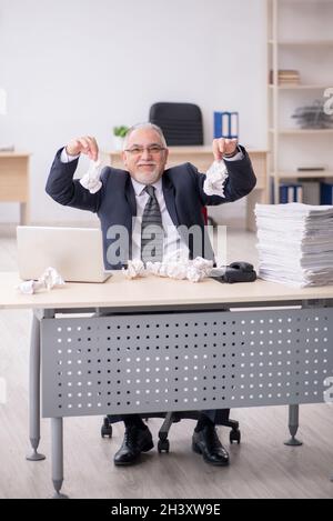 Old male employee in brainstorming concept Stock Photo