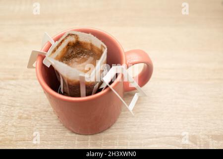 Coffee Drips in cup. Alternative brewing coffee in paper filter bags. Stock Photo