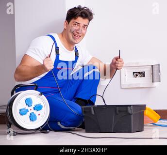 Funny Man doing electrical repairs at home Stock Photo