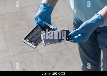 Broken screen mobile phone lies on ground. Stock Photo