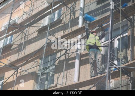 Worker on Scaffolding on building in the city. Stock Photo