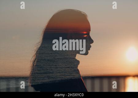 Young beautiful woman profile silhouette portrait at sunset. Stock Photo