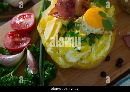 Tasty potato stuffed with eggs, bacon, cheese Stock Photo