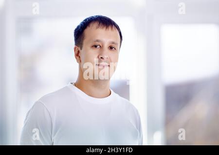 Portrait of young mixed race man who stands in living room. Stock Photo