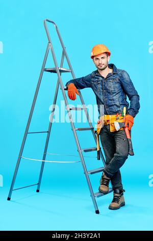 Full length portrait of handsome male construction worker climbing on ladder Stock Photo