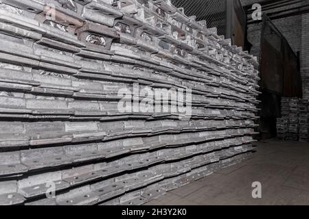 Iron parts of the workpiece for laying railway tracks metal structures in a heap at an industrial plant. Stock Photo