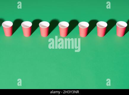 Row of red paper cup on green background with copy space Stock Photo