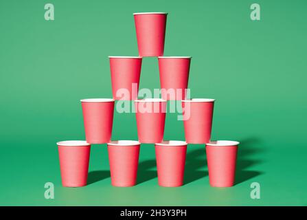 Pyramid of red paper cups on green background. minimalism concept Stock  Photo - Alamy