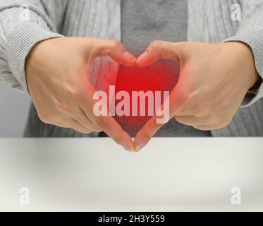 hand holding a heart shaped object white background copy space