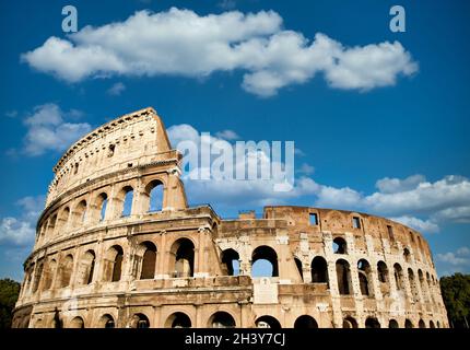 Rome, Italy. Arches archictecture of Colosseum exterior with blue sky background and clouds. Stock Photo