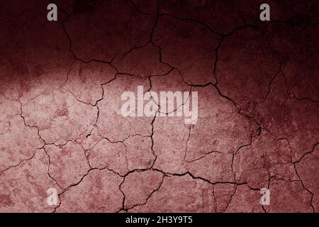 Dry cracked earth red Mars ground texture with spot light. No watering desert. Stock Photo