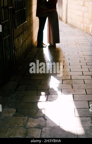 A loving couple in an alley between houses on paving slabs. Stock Photo