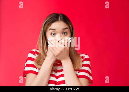 Close-up shocked asian woman gasping speechless press hands lips raise eyebrows impressed stunned, stare camera hear unbelievabl Stock Photo