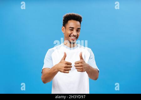 You doing great, support you. Satisfied creative and stylish young african american man with beard winking joyfully smiling broa Stock Photo