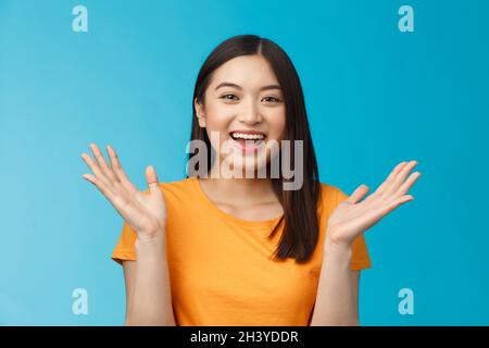 Close-up friendly happy cute asian female student clap hands joyfully, smiling broadly looking funny amusing performance, stand Stock Photo
