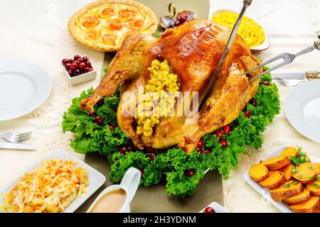 Fork and knife cut roasted whole turkey for Thanksgiving dinner. Stock Photo