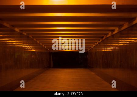 Tunnel at night. Light in the hallway. Lamps lines on the ceiling. Underground pedestrian crossing without people. Tunnel under the road in Moscow. Stock Photo