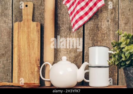 Two white vintage tea mugs and teapot on kitchen counter Stock Photo