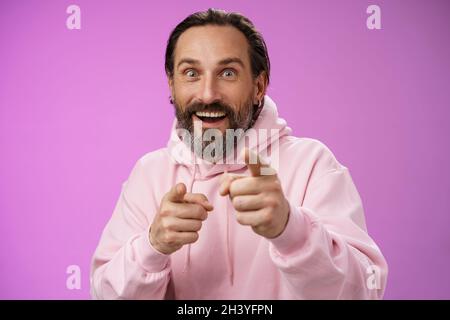 Thrilled energized charismatic happy lucky adult handsome bearded man pointing camera smiling widen eyes gazing impressed see fa Stock Photo