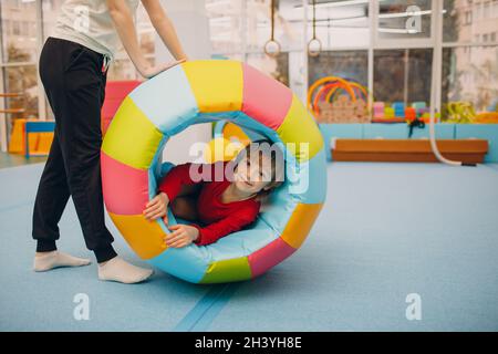 Kids playing in gym at kindergarten or elementary school. Children sport and fitness concept. Stock Photo