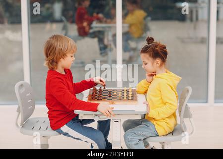 Little kids playing chess at kindergarten or elementary school Stock Photo