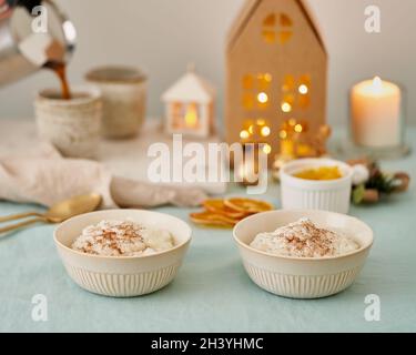 Faceless person pouring coffee from coffee maker to cup. Christmas food. Rice pudding Stock Photo