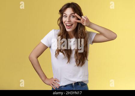 Playful surprised charismatic young caucasian girlfriend having fun look amused enthusiastic show peace victory sign laughing sm Stock Photo