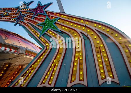 Colorful electric vintage amusement park ride lights with shooting stars Stock Photo