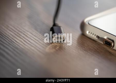 Magnetic cable for charging smartphone, close up. Stock Photo