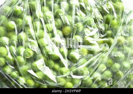 Fresh green frozen and peas grains in sachets, nutritious and healthy green vegetables Stock Photo