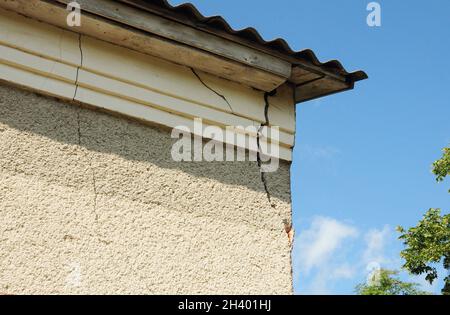 House wall stucco cracks on the roof corner. Stock Photo