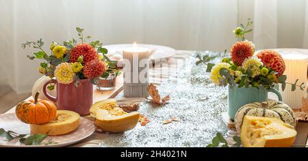 Festive table setting with pumpkins and chrysanthemum flowers. Stock Photo