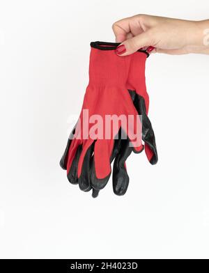 Female hand holds textile red work gloves on a white background. Protective clothing for manual workers Stock Photo