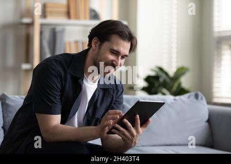 Happy young handsome man using digital computer tablet. Stock Photo
