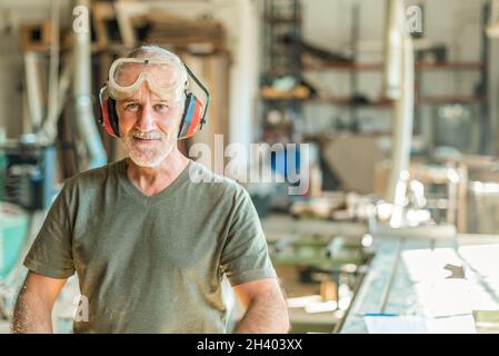 Worker smiling in the factory with the safety work equipment Stock Photo