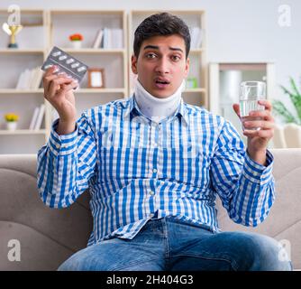 Young man suffering from neck injury at home Stock Photo