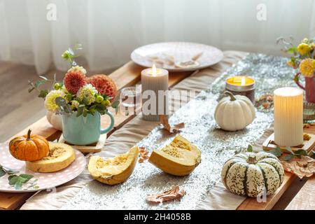 Festive table setting with pumpkins and chrysanthemum flowers. Stock Photo