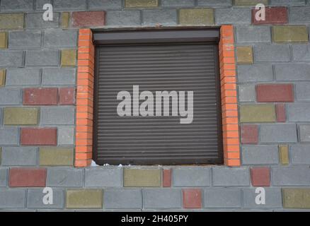 A house window with closed shutter security barrier. Stock Photo