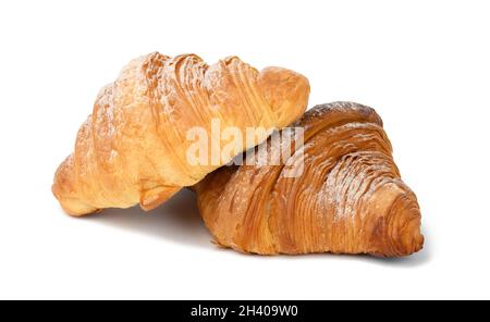 Two baked croissants on a white isolated background, dessert for breakfast sprinkled with powdered sugar Stock Photo