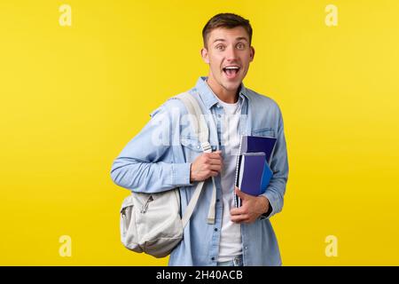 Education, courses and university concept. Surprised happy smiling guy seeing something amazed while heading to class in college Stock Photo