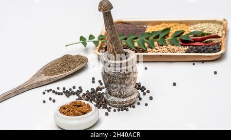 Curry Masala Powder with ingredients with fresh curry leaf in palm leaf plate, curry powder in Indian kitchen. Stock Photo