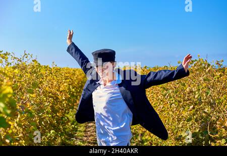 girl in a jacket walks among the vineyards Stock Photo